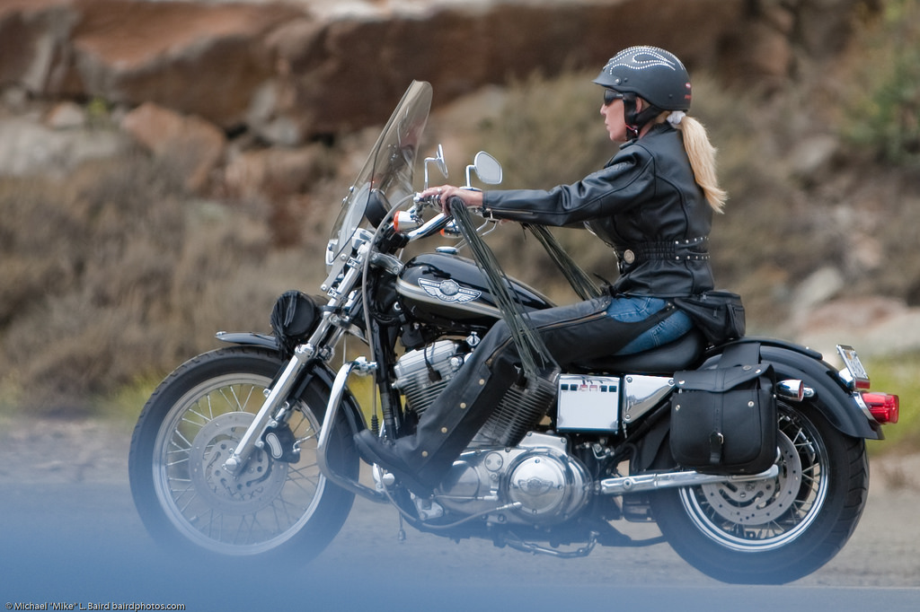 Female motorcycle biker in leathers, blond ponytail, in Morro Bay, CA 16 August 2009. Photo by Michael "Mike" L. Baird, mike at mikebaird d o t com, flickr.bairdphotos.com, Canon 1D Mark III, Canon 70-200mm f/2.8 handheld.