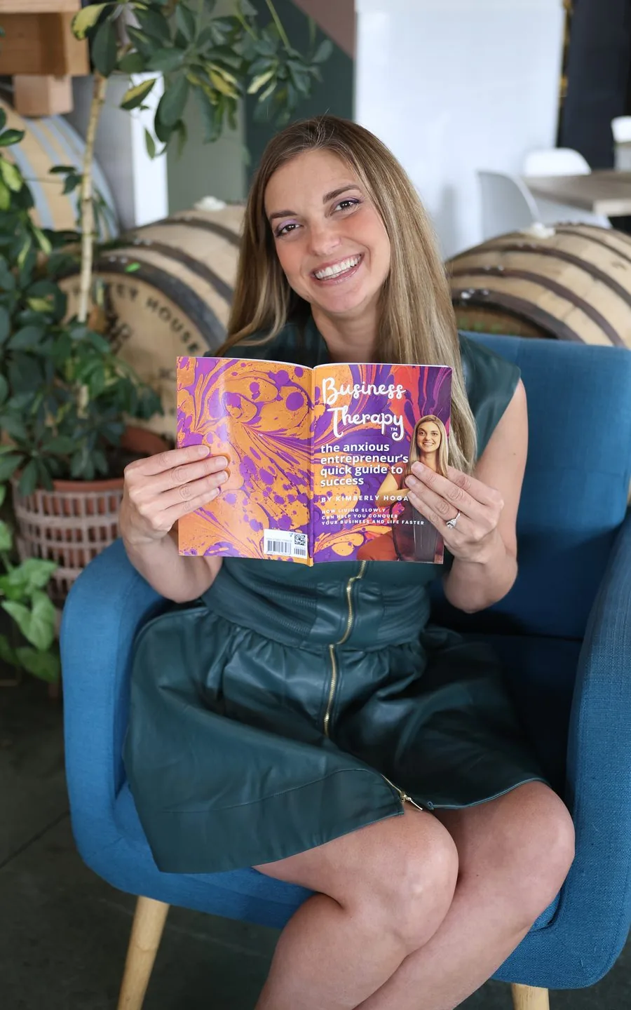 Kimberly Hogate holding her book, Business Therapy