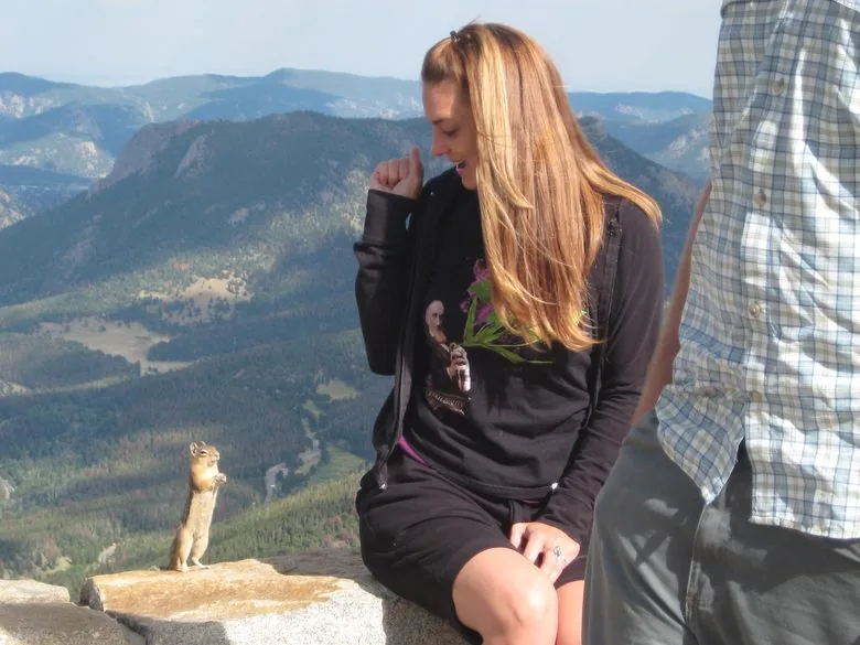 Kimberly Hogate being negotiated with by a chipmunk on a Colorado summit
