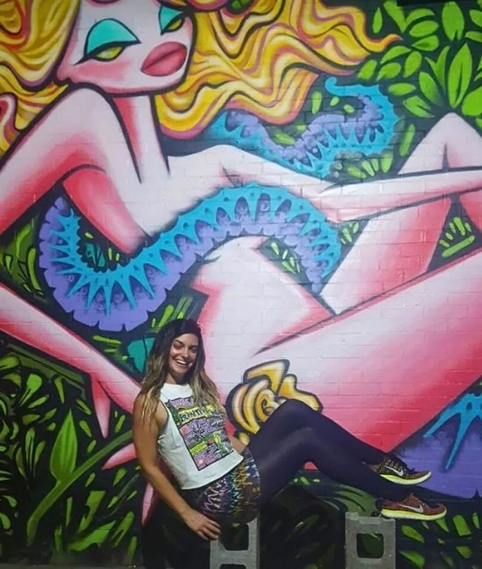 Kimberly Hogate in front of a large street art mural